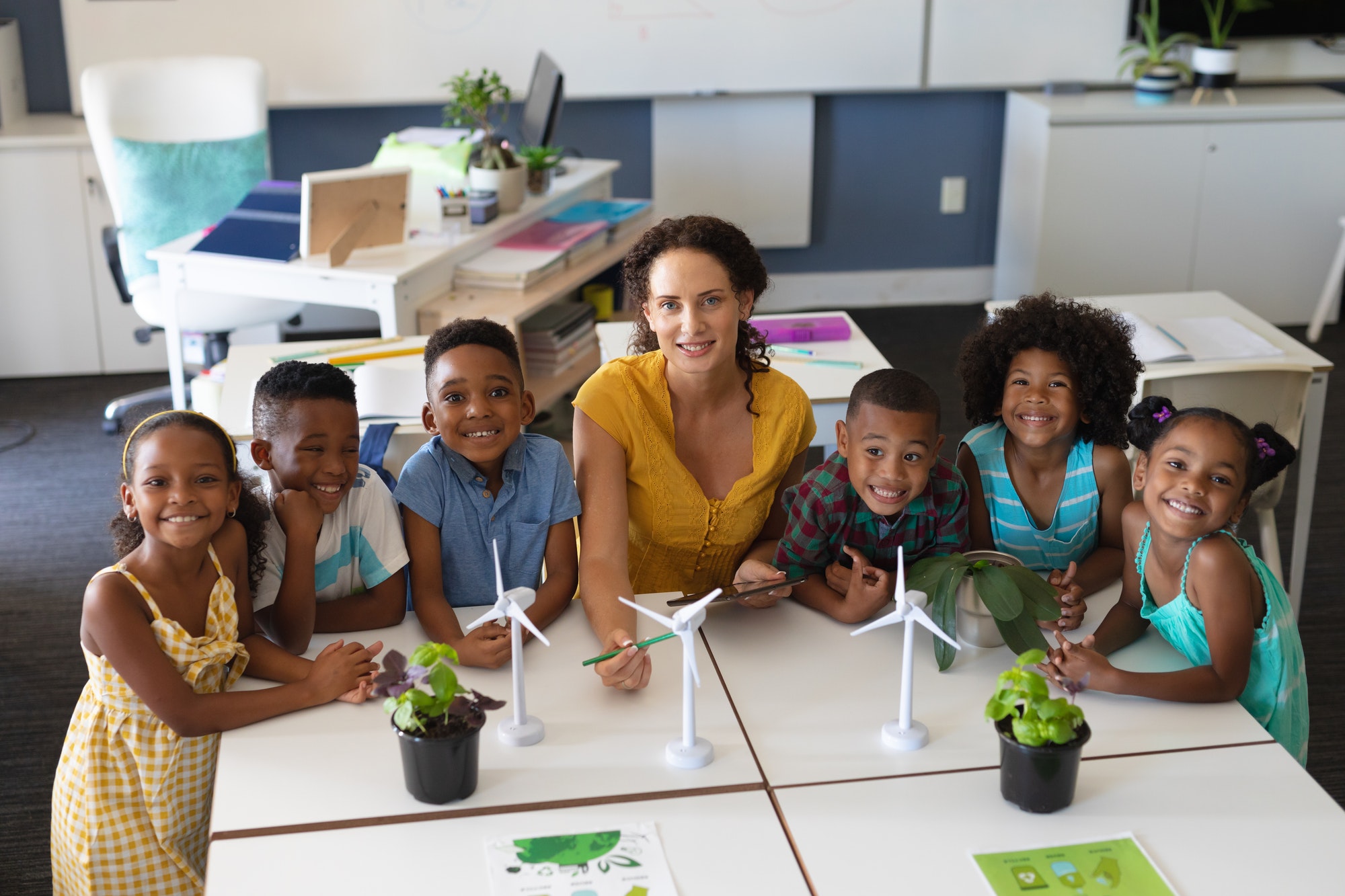 Portrait of african american students with caucasian young female teacher with windmill models