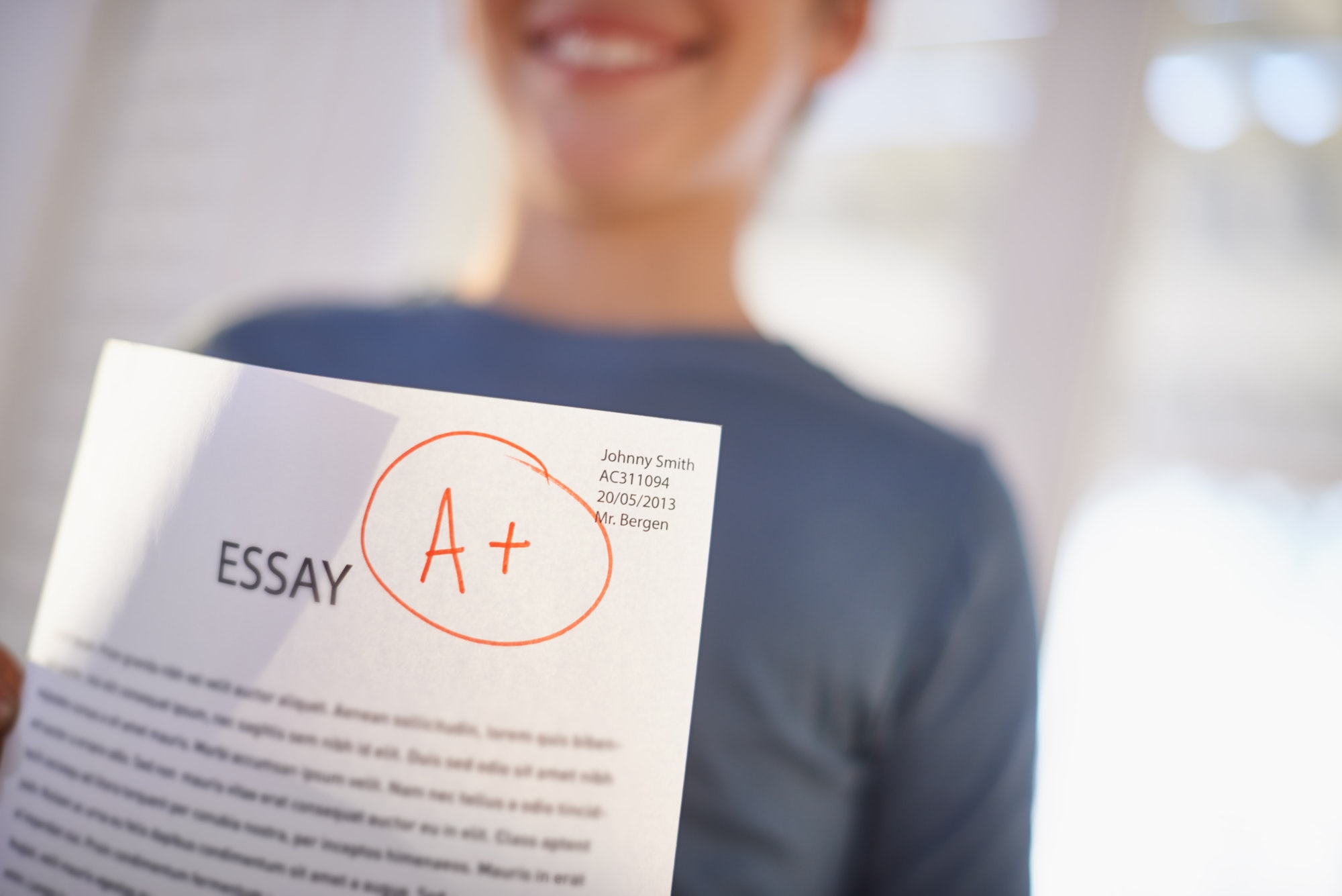 Easy A. Shot of a proud young boy holding up his essay that got him an A.